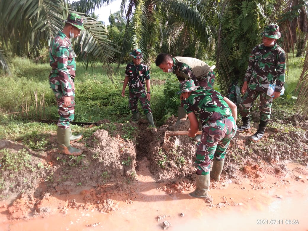 Diguyur Hujan Deras, Anggota Satgas TMMD Goro Buang Genangan Air