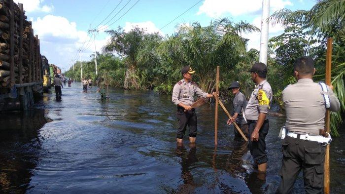 Polisi Beri Tanda Pembatasan Jalan di Lokasi Banjir Jalintim Pelalawan
